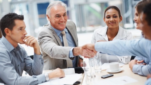 Senior businessman congratulating a person during a meeting